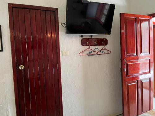 a television hanging on a wall next to a door at Hotel Las Flores in Xalapa