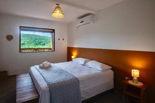 um quarto com uma cama grande e uma janela em Casa Brisa do Vale - Lençóis - BA em Lençóis