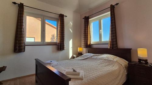 a bedroom with a large bed with two windows at Seaside holiday house Jadrija, Sibenik - 24454 in Jadrija
