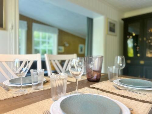 a wooden table with plates and glasses on it at The Buar Cabin in Strömstad