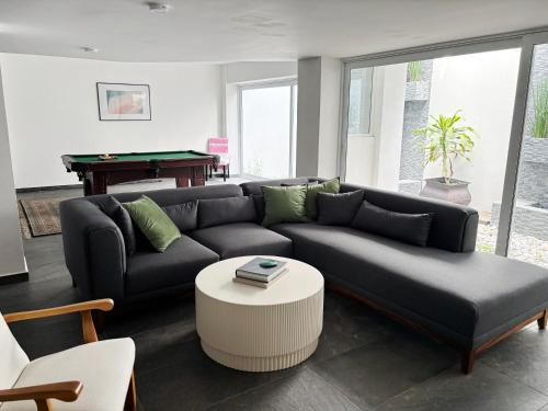 een woonkamer met een bank en een pooltafel bij Casa Loma next to Xochimilco in Oaxaca City