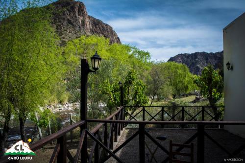 a street light next to a bridge with trees and mountains at Carü Leufu in Valle Grande