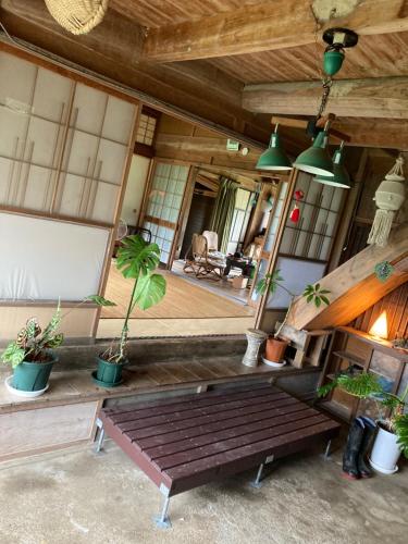 a porch with a wooden bench and potted plants at 竜野園藝 in Kamimashiki