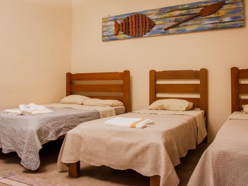 a room with two beds with towels on them at Pousada Refugio Prumirim in Ubatuba