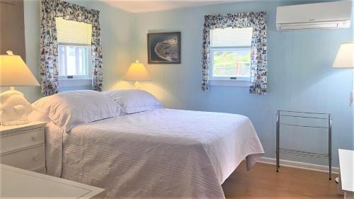a blue bedroom with a bed and two windows at Little Sandpiper in Cape May Point