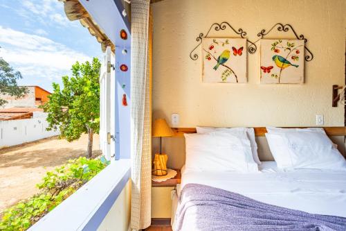 a bedroom with a bed and a window at Casinha Ipê Roxo - Condomínio Quinta do Rosário in Pirenópolis
