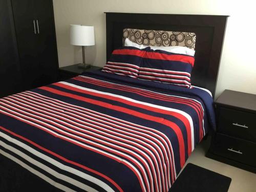 a bedroom with a large bed with a striped blanket at Departamento Durango Jade in Durango