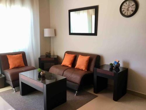 a living room with a couch and two tables and a clock at Departamento Durango Jade in Durango