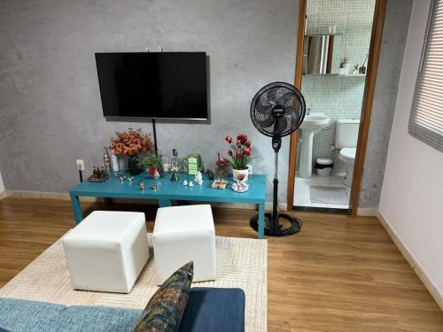 a living room with a blue table and a fan at Riacho Fundo I 201- Boa acomodação com economia in Brasilia