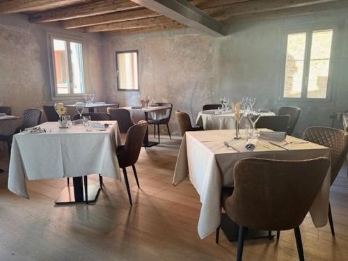 a restaurant with tables and chairs with white tablecloths at Locanda ai Provveditori in Marano Lagunare