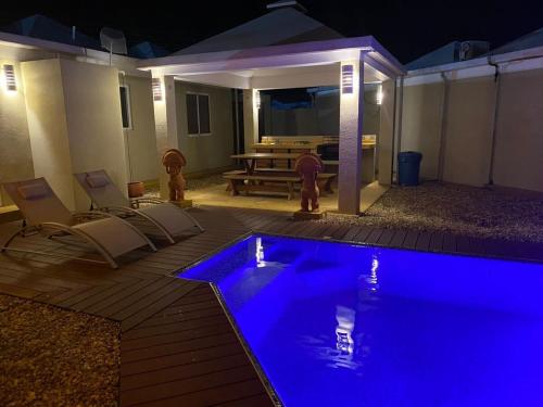 a swimming pool at night with chairs and a table at La Vaquera - Morrocoy in Sanare