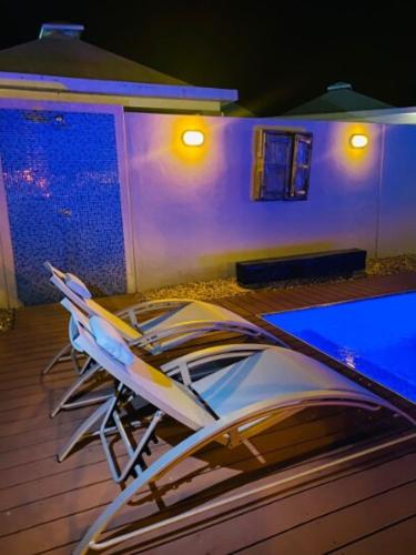 a pair of chairs sitting on a deck at night at La Vaquera - Morrocoy in Sanare