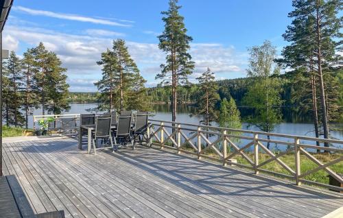 奥尔延Amazing Home In Årjäng With Lake View的一个带桌椅的甲板,俯瞰着湖泊