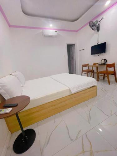 a bedroom with a bed and a table and a tv at Khách sạn LyLy 3 in Thuan An