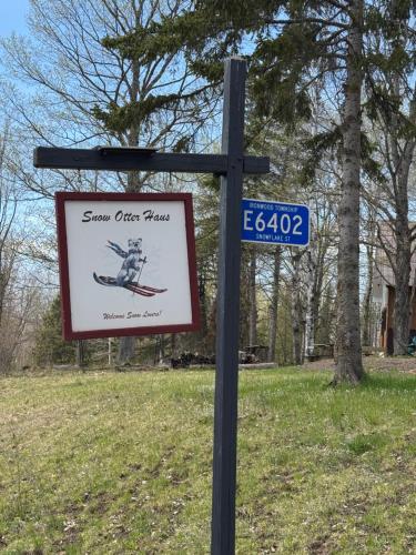 a sign on a pole with a street sign at Snow Otter Haus in Bessemer