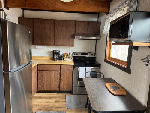 a kitchen with a stainless steel refrigerator and a table at Snow Otter Haus in Bessemer