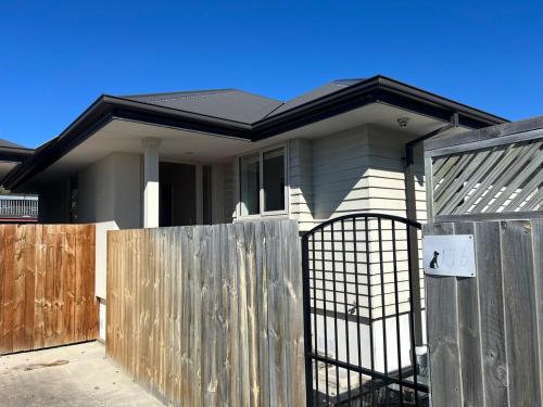 a house with a gate and a fence at Spacious 3 BR house near sumner in Christchurch