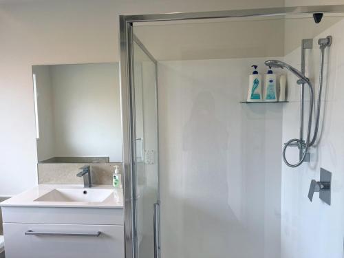 a bathroom with a shower and a sink at Spacious 3 BR house near sumner in Christchurch