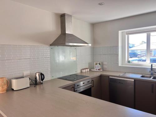 a kitchen with a sink and a stove top oven at Spacious 3 BR house near sumner in Christchurch