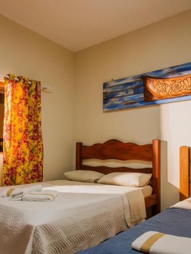 a bedroom with two beds and a window at Pousada Refugio Prumirim in Ubatuba
