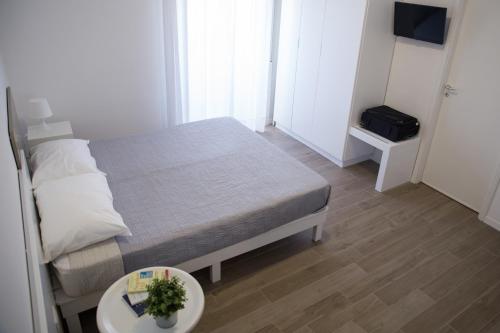 a small bedroom with a bed and a table at Baia Del Sole in Licata