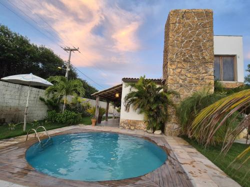 a swimming pool in front of a house at Chalés Refúgio Fortim in Fortim