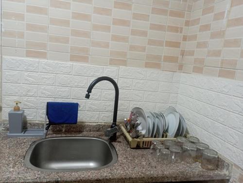 a kitchen sink with a faucet and water glasses at Eyad Pyramids view in Cairo