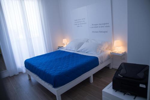 a bedroom with a bed with a blue blanket at Baia Del Sole in Licata