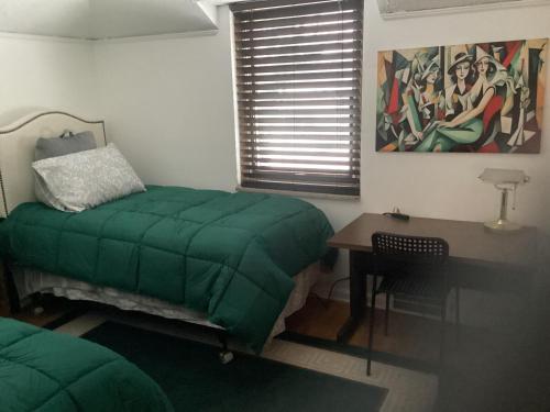 a bedroom with a green bed and a desk at 3 bedroom colonial house in Royal Oak