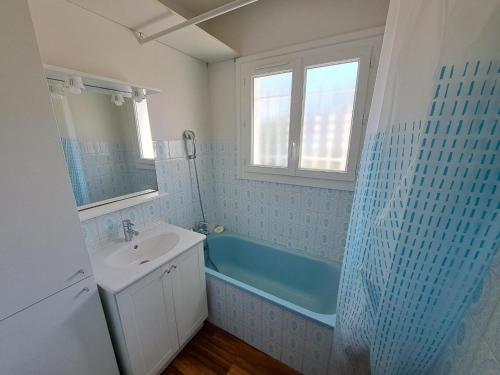 une salle de bain avec une baignoire, un lavabo et une douche dans l'établissement Maison 3 Chambres avec Jardin et Wi-Fi à 10 min de la Plage, Quartier Calme, Animaux Acceptés - FR-1-323-370, à Saint-Jean-de-Monts