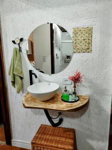a bathroom with a sink and a mirror at Chalé Elohim Campos do Jordão in Campos do Jordão