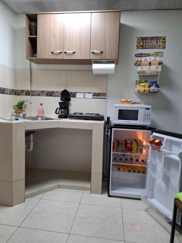 a kitchen with an open refrigerator and a microwave at Casa Lilia Airport in Panama City