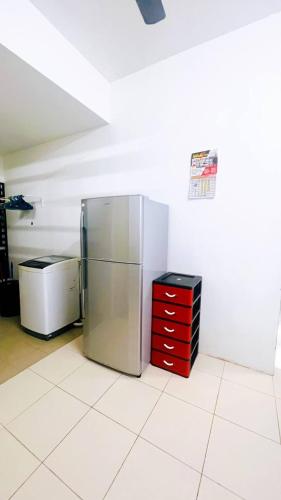 a kitchen with a stainless steel refrigerator and a red dresser at APPARTMENT Samudera Manjung Point in Seri Manjung