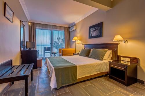 a hotel room with a bed and a balcony at Cunda Hotel in Ayvalık