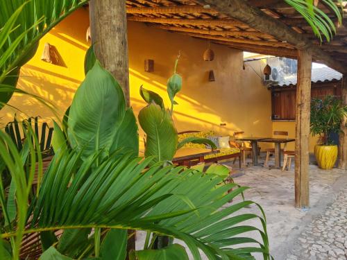 a patio with a table and some green plants at Chalés Refúgio Fortim in Fortim