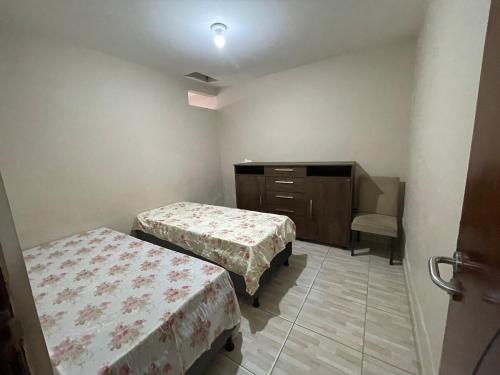 a small room with two beds and a dresser at Casa Paris in Caruaru