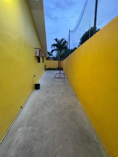 a yellow wall in a parking lot next to a building at Casa Celine Dumaguete in Dumaguete
