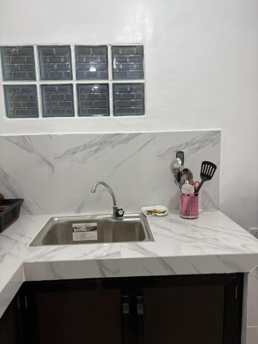 a kitchen counter with a sink and utensils at Casa Celine Dumaguete in Dumaguete