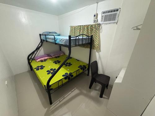 a room with a bunk bed and a chair at Casa Celine Dumaguete in Dumaguete