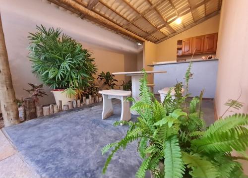 a room with plants and a table in the middle at Chalés Refúgio Fortim in Fortim