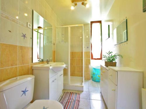 une salle de bain avec toilettes, lavabo et miroir dans l'établissement Maison familiale avec piscine en pleine nature, proche Dordogne et sites touristiques - FR-1-616-217, à Calviac