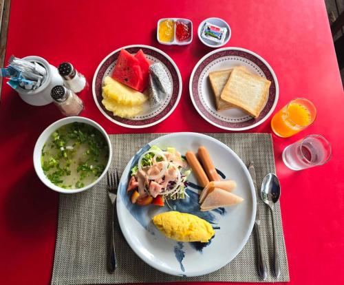 a red table with a plate of food on it at First Pacific Cirrus in Pattaya Central