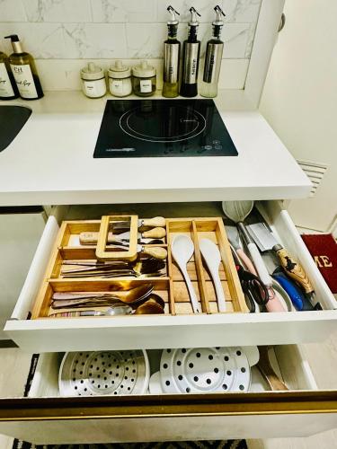 a drawer of a refrigerator filled with lots of utensils at Chic Hideaway at Azure North Bali Tower in San Fernando