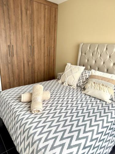 a bedroom with a bed with a wooden cabinet at Alojamiento en Las Quintas in Tunja
