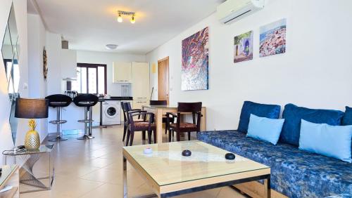 un salon avec un canapé bleu et une table dans l'établissement Séjour calme au Golf & Gardens, à Cabo Negro