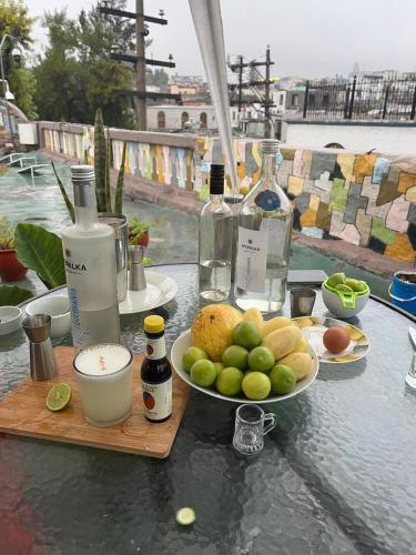 een tafel met een schaal fruit en flessen wijn bij Orkkowasi backpackers in Arequipa