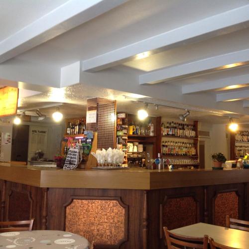 a bar in a restaurant with tables and chairs at Auberge du Meygal in Champclause