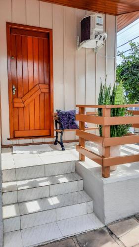 a bench sitting in front of a house with a door at Hospedagem Don Panizzi in Bento Gonçalves