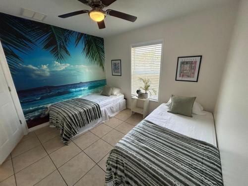 two beds in a room with a palm tree mural at Tropical 3bed 2bath Lakeland Home on corner lot in Lakeland