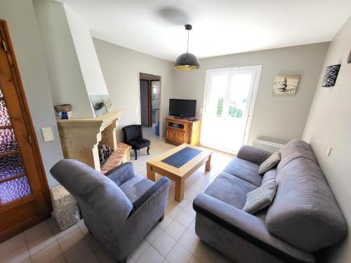 un salon avec un canapé et une table dans l'établissement Maison paisible avec jardin, garage, WiFi, proche plage et commerces - FR-1-92-798, à Les Sables-dʼOlonne